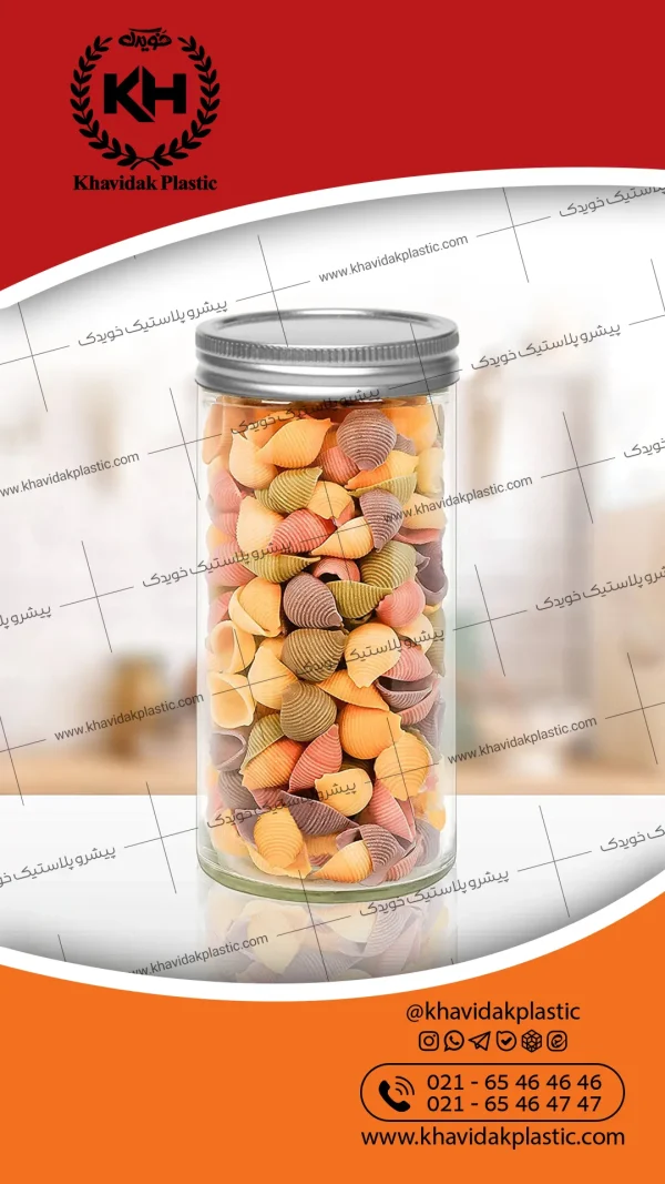 یک جار پلاستیکی استوانه ای شفاف ۱۰۰۰ سی سی با درب فلزی نقره ای پر شده از ماکارانی صدفی رنگارنگ - ظرف پت مخصوص بسته بندی پاستا و ماکارانی - محصول بطری سازی خویدک